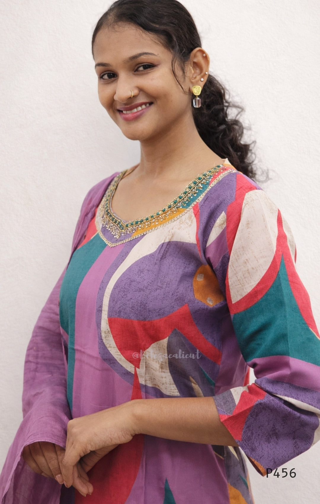 Woman wearing a colorful traditional outfit with a white background