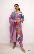 Woman wearing a colorful outfit with a purple dupatta against a white background