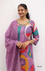 Woman wearing a colorful outfit with a purple cardigan against a white background