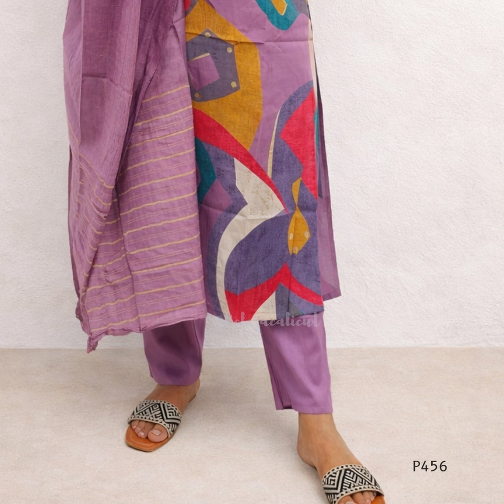 Colorful traditional outfit with a patterned drape on a plain background
