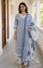 Woman wearing a blue and white striped kurta with a matching dupatta on a porch.