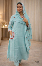 Woman wearing a light blue traditional outfit with a matching dupatta indoors.