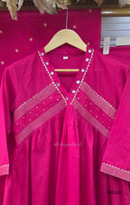 Rani pink cotton churidar suit set with matching bottom and dupatta, mirror detail V-neckline, gold line work on yoke, and festive casual styling.