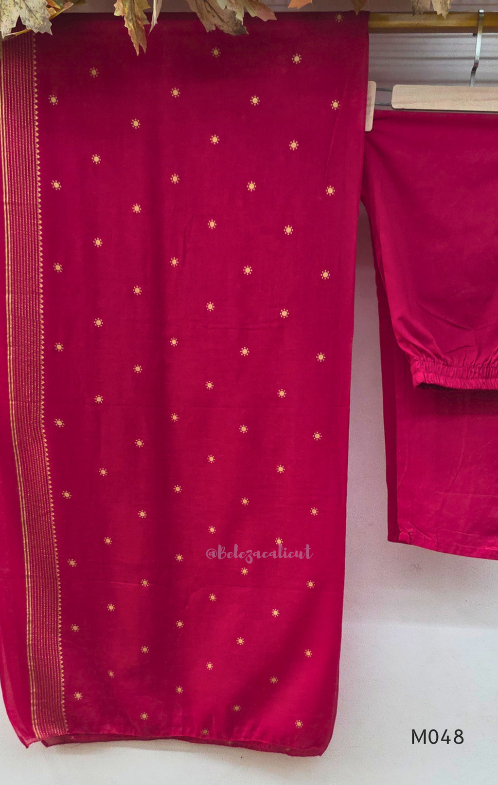 Rani pink cotton churidar suit set with matching bottom and dupatta, mirror detail V-neckline, gold line work on yoke, and festive casual styling.