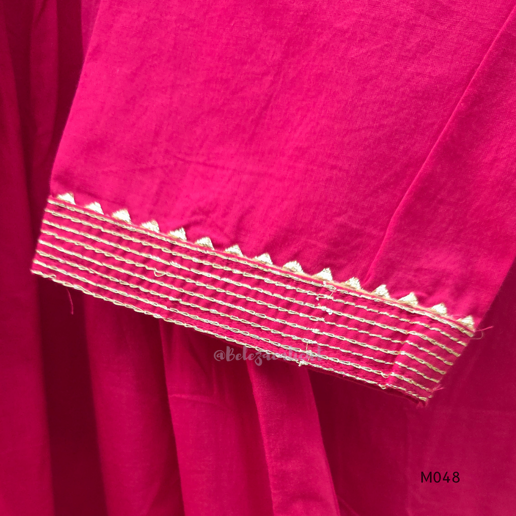 Rani pink cotton churidar suit set with matching bottom and dupatta, mirror detail V-neckline, gold line work on yoke, and festive casual styling.