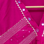 Rani pink cotton churidar suit set with matching bottom and dupatta, mirror detail V-neckline, gold line work on yoke, and festive casual styling.