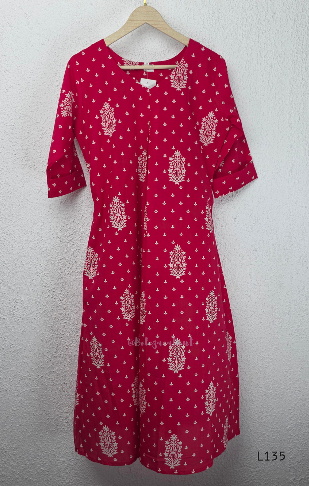 Raspberry pink cotton kurta top with white floral buti print, centre pleat detail, 3/4 sleeves, and relaxed A-line fit.