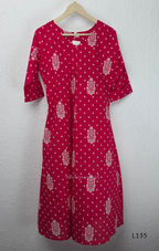 Raspberry pink cotton kurta top with white floral buti print, centre pleat detail, 3/4 sleeves, and relaxed A-line fit.