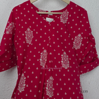 Raspberry pink cotton kurta top with white floral buti print, centre pleat detail, 3/4 sleeves, and relaxed A-line fit.