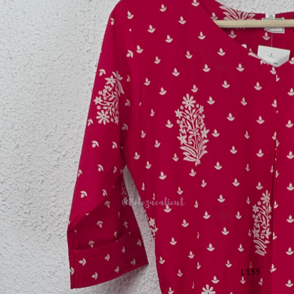 Raspberry pink cotton kurta top with white floral buti print, centre pleat detail, 3/4 sleeves, and relaxed A-line fit.