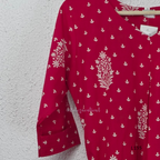 Raspberry pink cotton kurta top with white floral buti print, centre pleat detail, 3/4 sleeves, and relaxed A-line fit.