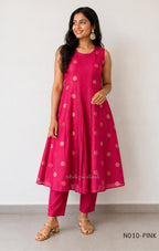 Raspberry pink Vertigan silk coord set with sleeveless pleated A-line top, gold circular side motifs and matching straight pants.