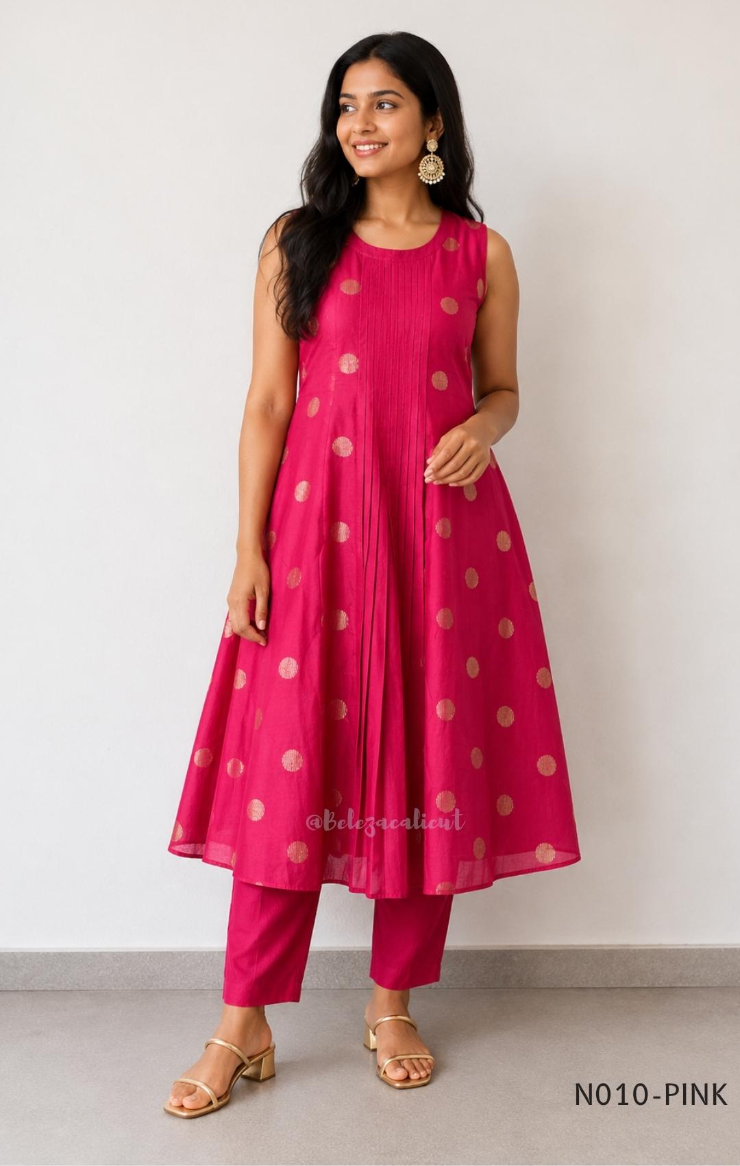 Raspberry pink Vertigan silk coord set with sleeveless pleated A-line top, gold circular side motifs and matching straight pants.