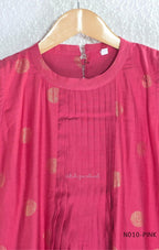 Raspberry pink Vertigan silk coord set with sleeveless pleated A-line top, gold circular side motifs and matching straight pants.