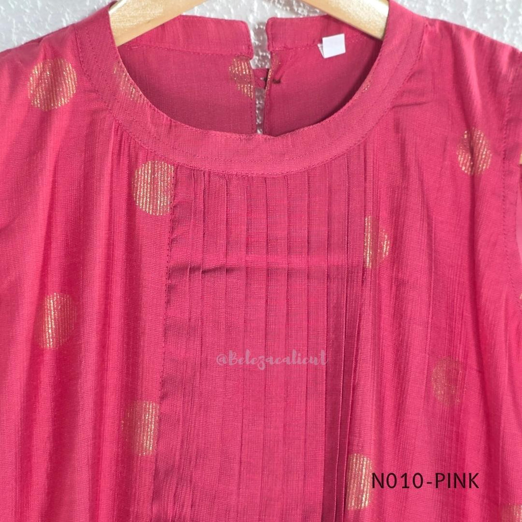 Raspberry pink Vertigan silk coord set with sleeveless pleated A-line top, gold circular side motifs and matching straight pants.