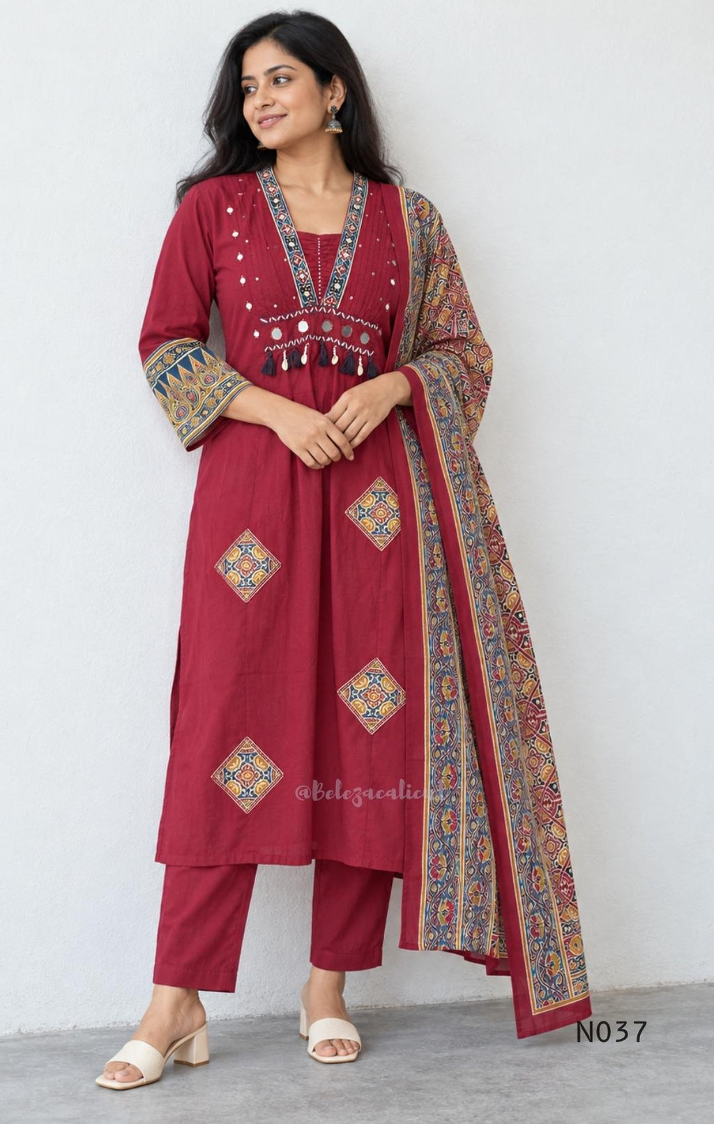 Raspberry red cotton 3-piece churidar set with a printed V-neck border, mirror-and-tassel yoke, diamond motifs, printed sleeves, straight pants and a printed dupatta.