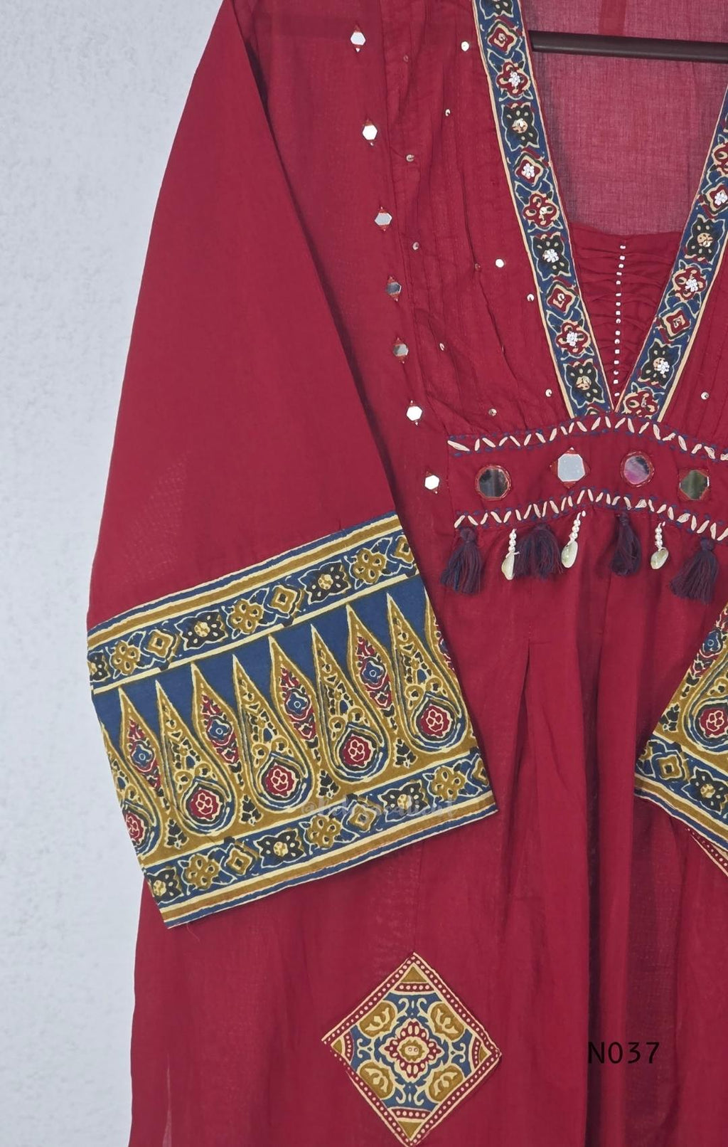 Raspberry red cotton 3-piece churidar set with a printed V-neck border, mirror-and-tassel yoke, diamond motifs, printed sleeves, straight pants and a printed dupatta.