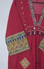 Raspberry red cotton 3-piece churidar set with a printed V-neck border, mirror-and-tassel yoke, diamond motifs, printed sleeves, straight pants and a printed dupatta.