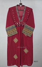 Raspberry red cotton 3-piece churidar set with a printed V-neck border, mirror-and-tassel yoke, diamond motifs, printed sleeves, straight pants and a printed dupatta.
