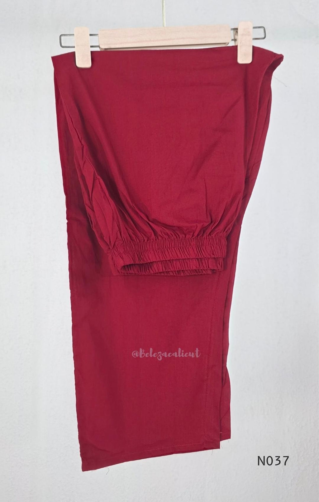 Raspberry red cotton 3-piece churidar set with a printed V-neck border, mirror-and-tassel yoke, diamond motifs, printed sleeves, straight pants and a printed dupatta.