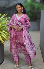 Woman wearing a pink traditional outfit with a patterned dupatta, standing outdoors.