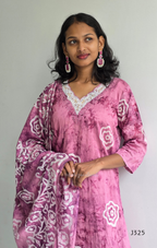 Woman wearing a pink and white patterned outfit against a plain background