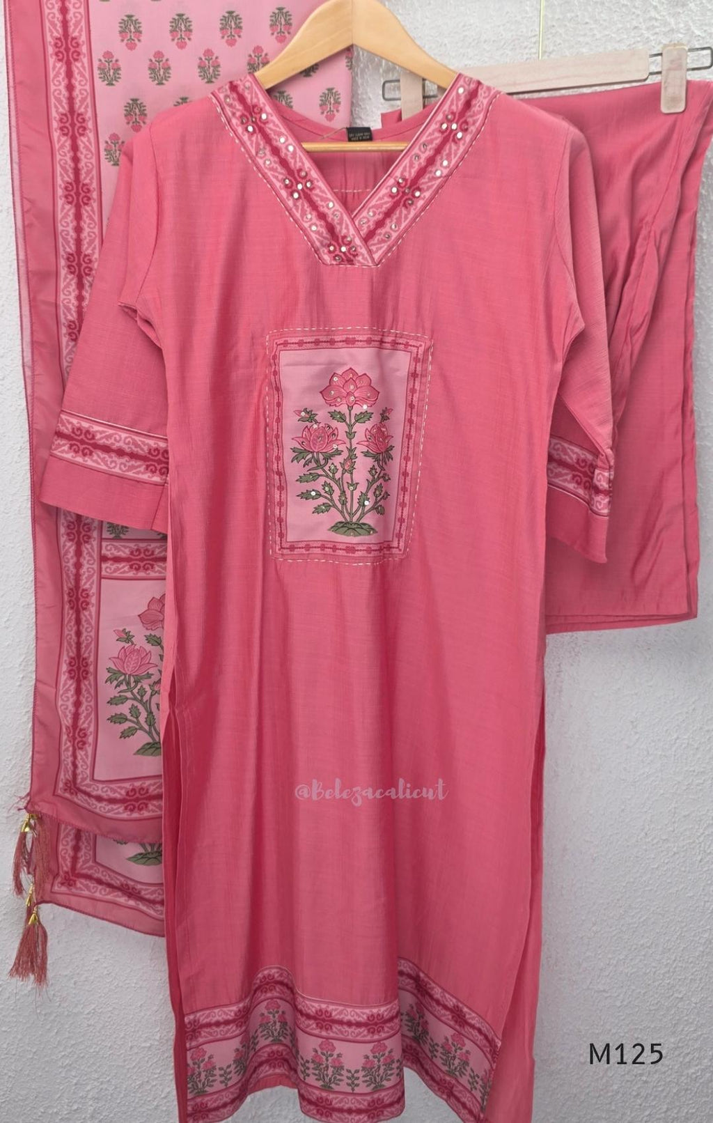 Rose pink silk blend 3-piece churidar set with floral patch panels, decorated V-neck, loose plain bottom and printed floral dupatta.