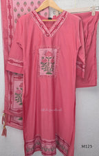 Rose pink silk blend 3-piece churidar set with floral patch panels, decorated V-neck, loose plain bottom and printed floral dupatta.