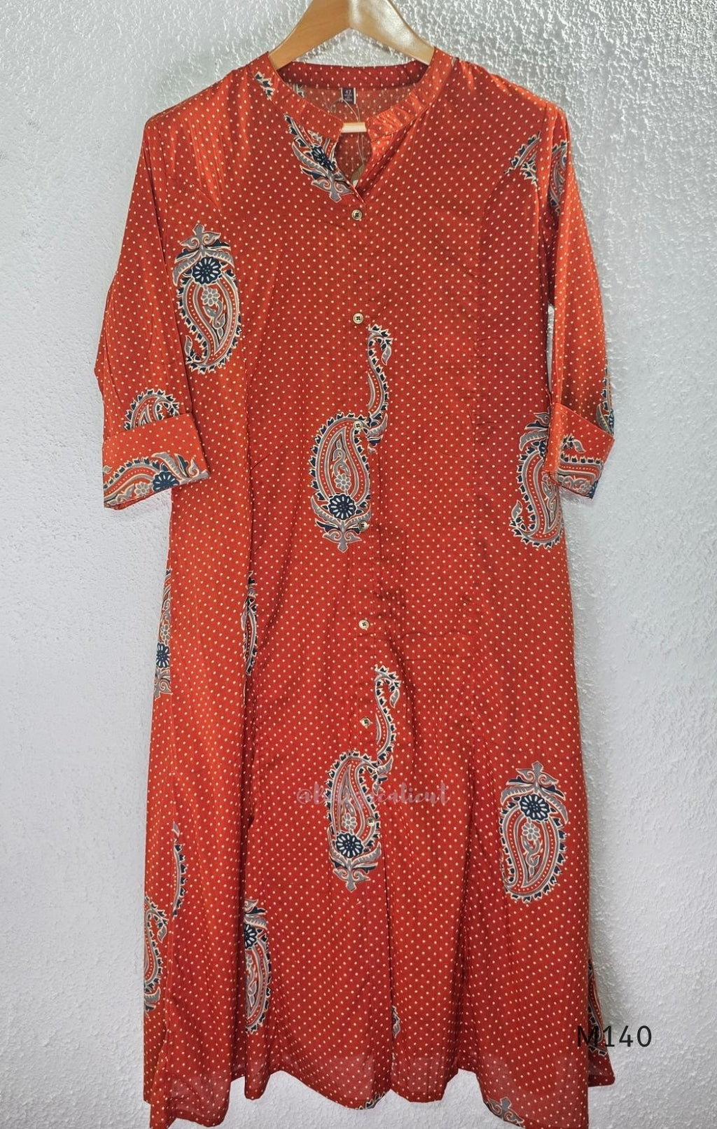 Rust-orange cotton co-ord set with dotted paisley print, A-line top and straight wide-leg bottom.