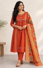 Rust-orange cotton churidar set with decorative patchwork-style trims, gathered yoke, straight pants and printed dupatta.