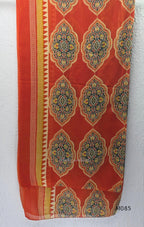 Rust-orange cotton churidar set with decorative patchwork-style trims, gathered yoke, straight pants and printed dupatta.