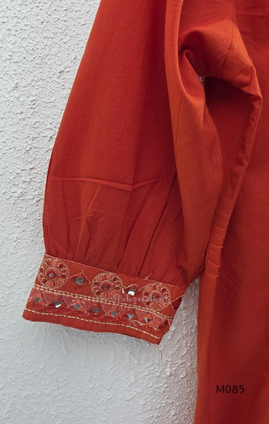 Rust-orange cotton churidar set with decorative patchwork-style trims, gathered yoke, straight pants and printed dupatta.
