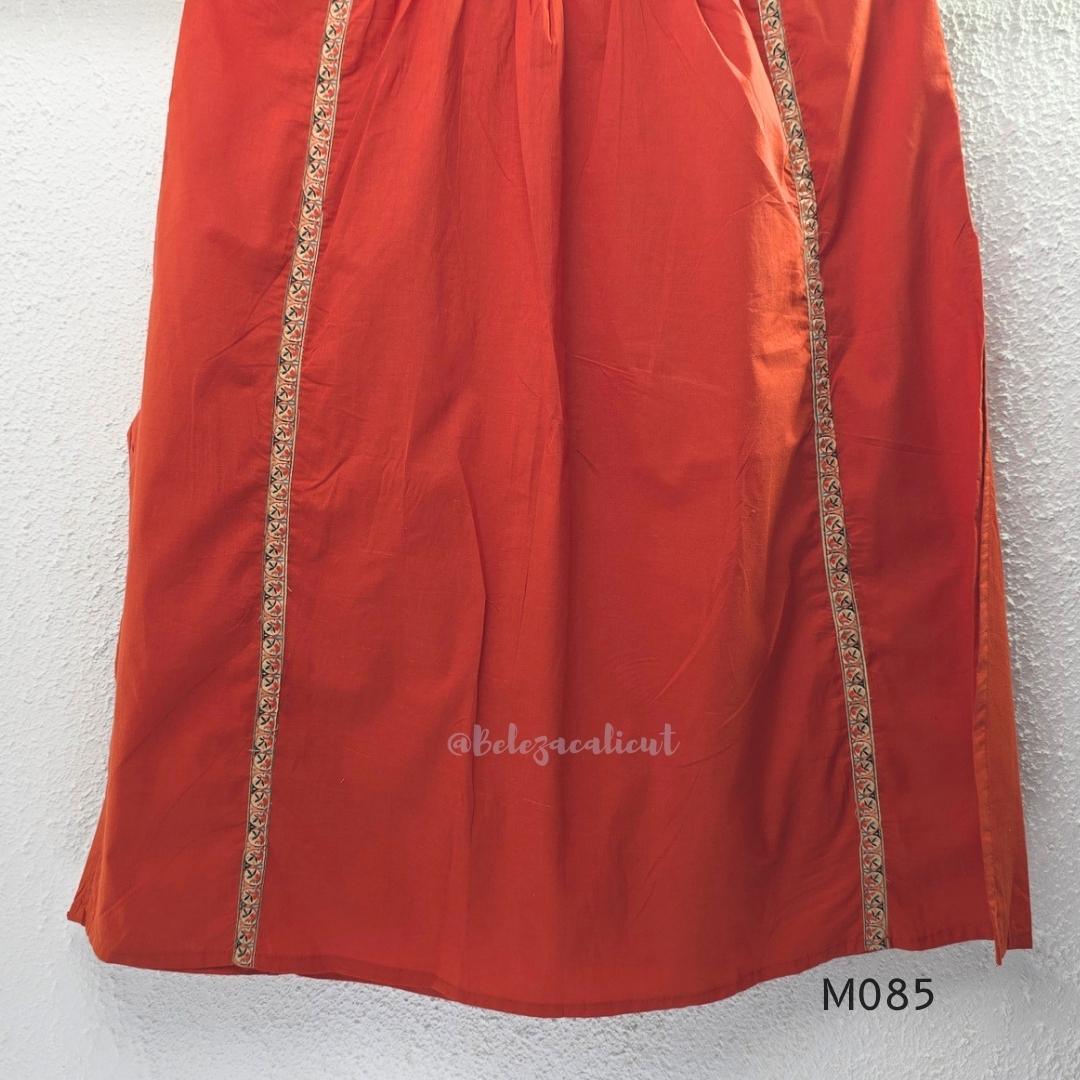 Rust-orange cotton churidar set with decorative patchwork-style trims, gathered yoke, straight pants and printed dupatta.