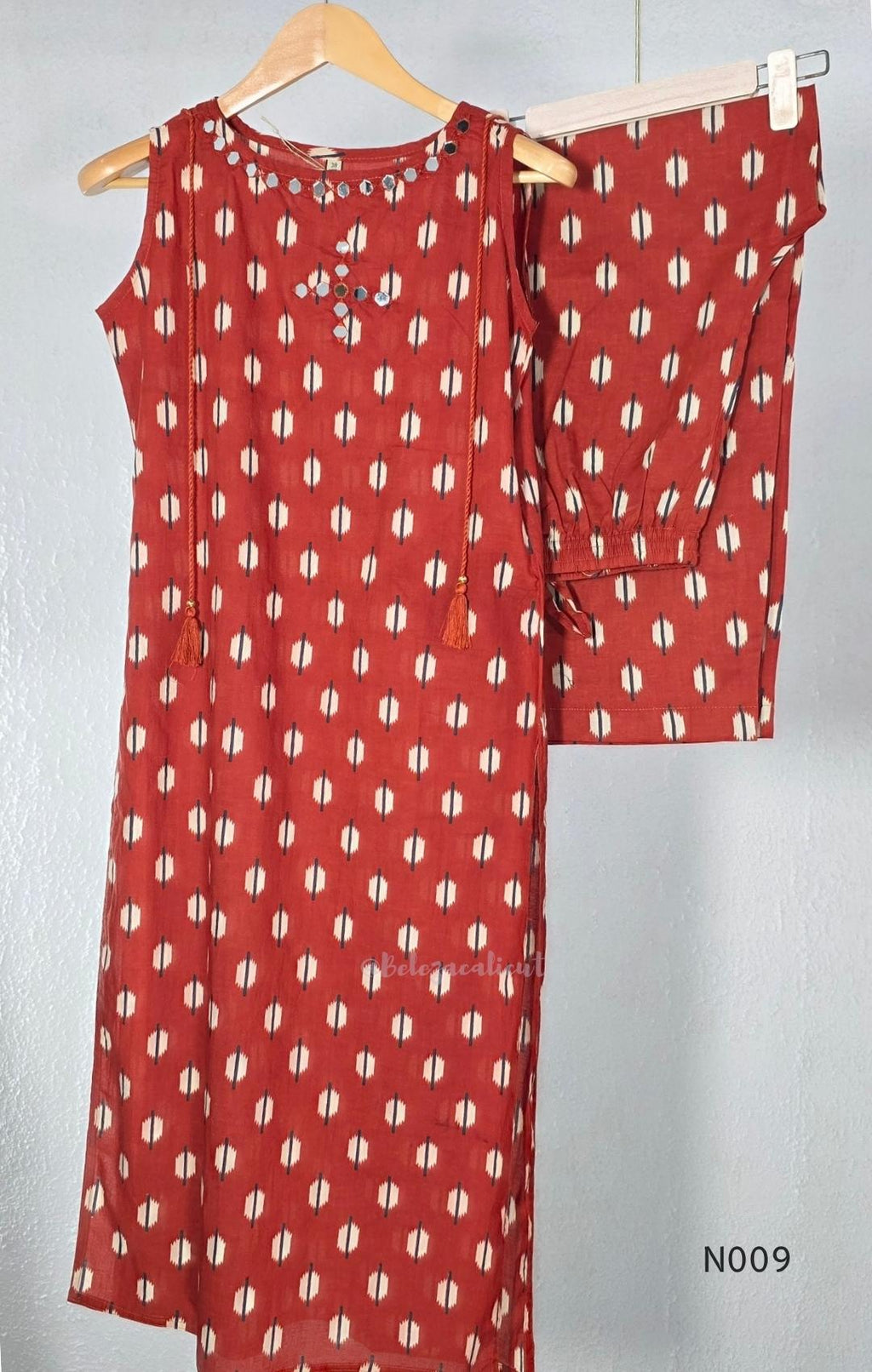 Rust red cotton 2-piece co-ord set with cream and navy motifs, mirror neckline detail and relaxed wide-fit pants.
