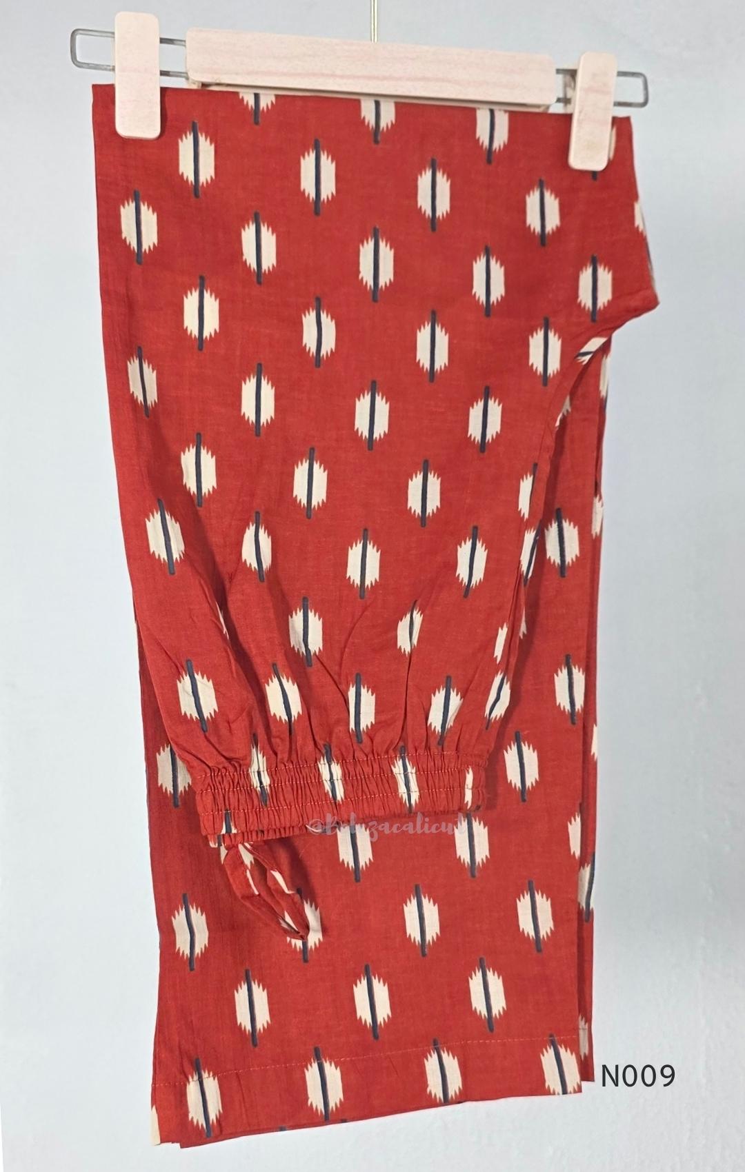 Rust red cotton 2-piece co-ord set with cream and navy motifs, mirror neckline detail and relaxed wide-fit pants.