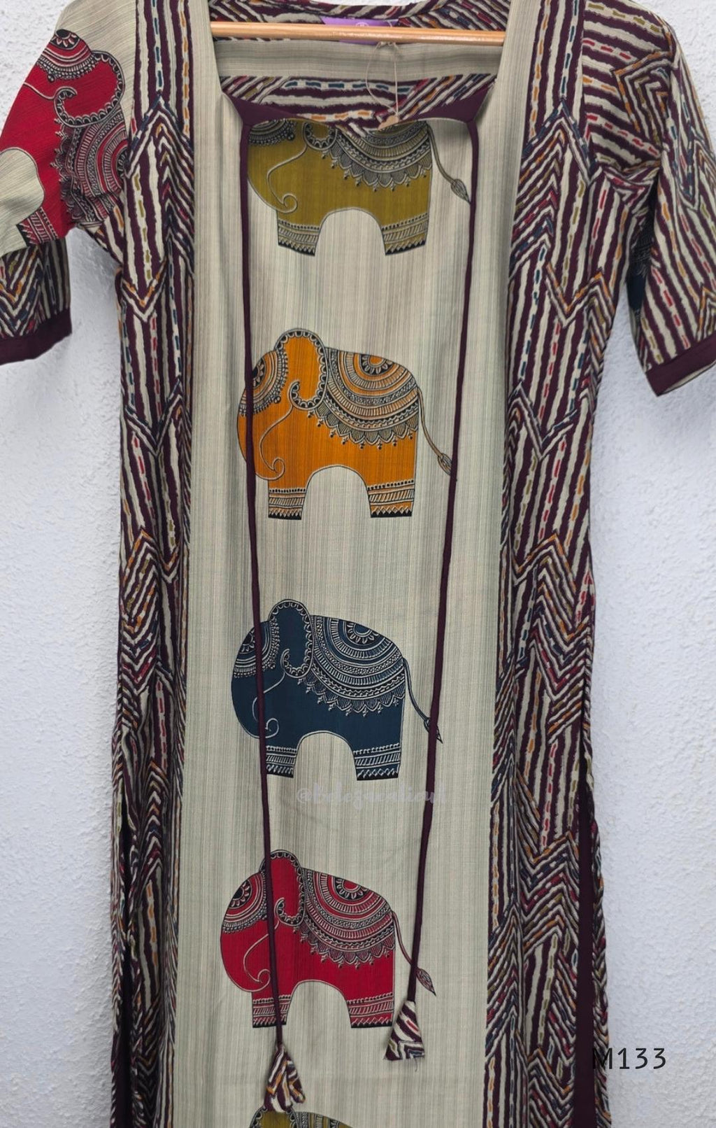 Sand beige silk blend long kurta with multicolour elephant motifs, maroon chevron side panels and contrast half sleeves.