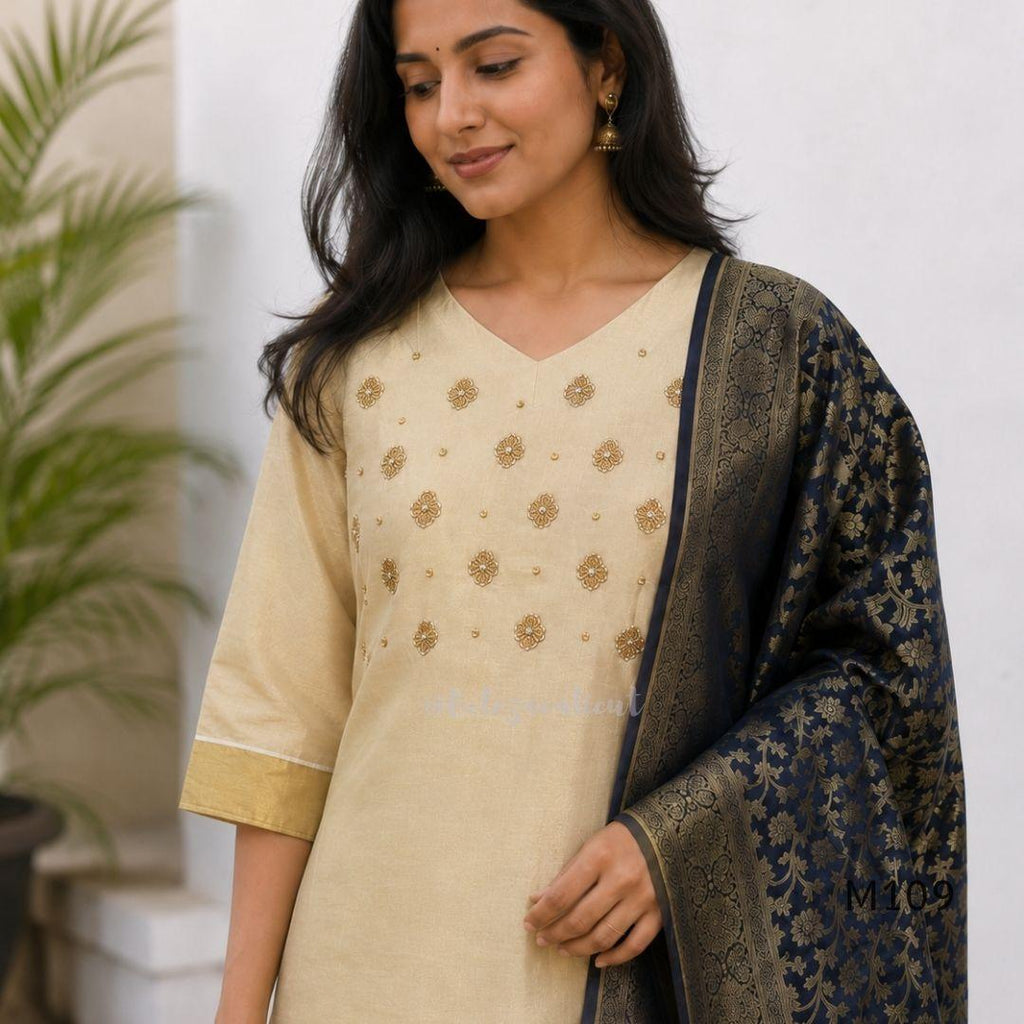 Soft gold tissue silk blend 3-piece set with gold front embroidery, matching bottom and deep navy antique gold zari dupatta.