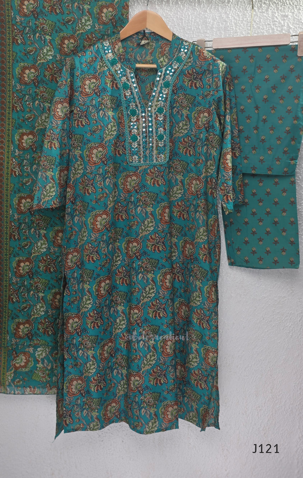 Teal blue Jaipur cotton churidar set with floral print, mirror-work neckline, matching printed bottom and dupatta.