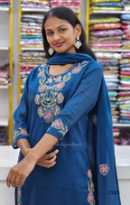 Woman wearing a blue embroidered outfit in a fabric store