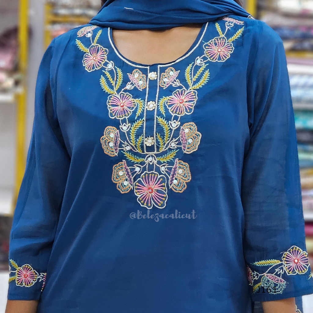 Blue embroidered garment with floral patterns on a blurred background