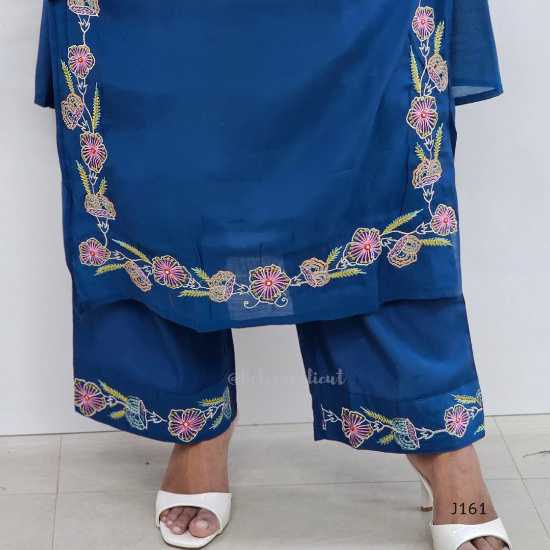 Blue embroidered outfit with white sandals on a light background