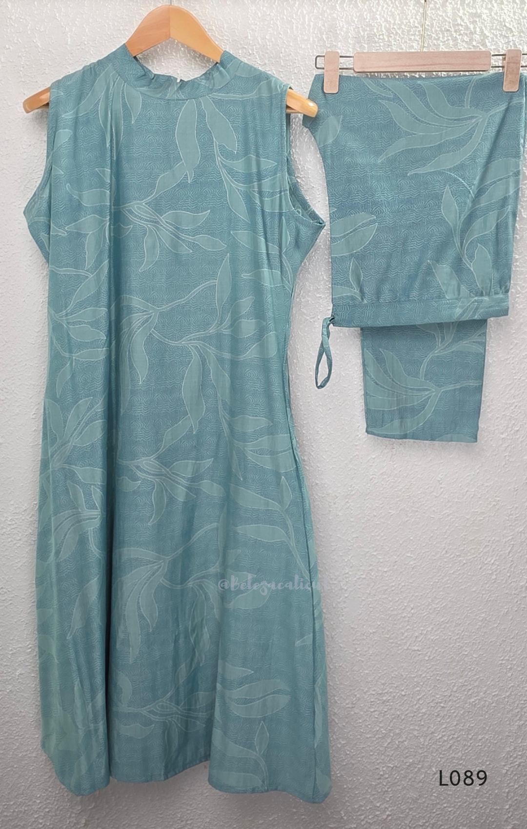 eal blue rayon blend 2-piece set with leaf line print, high neck top, back zip and matching printed straight pant.