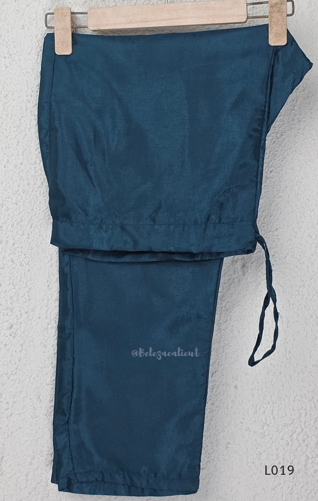 Deep teal blue silk blend 3-piece churidar set with square white floral threadwork embroidery yoke with bead droplet border, straight cut kurti with 3/4 sleeves, matching plain teal bottom with drawstring, and teal chiffon dupatta with scattered silver sequin dots, Indian ethnic wear from Beleza Calicut