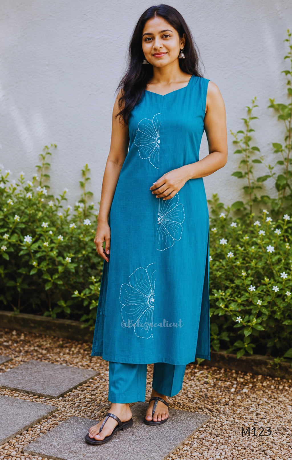 eal blue Vertigan silk coord set with white floral embroidery and straight pants.