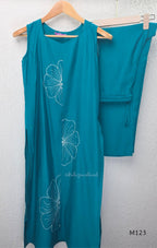 eal blue Vertigan silk coord set with white floral embroidery and straight pants.