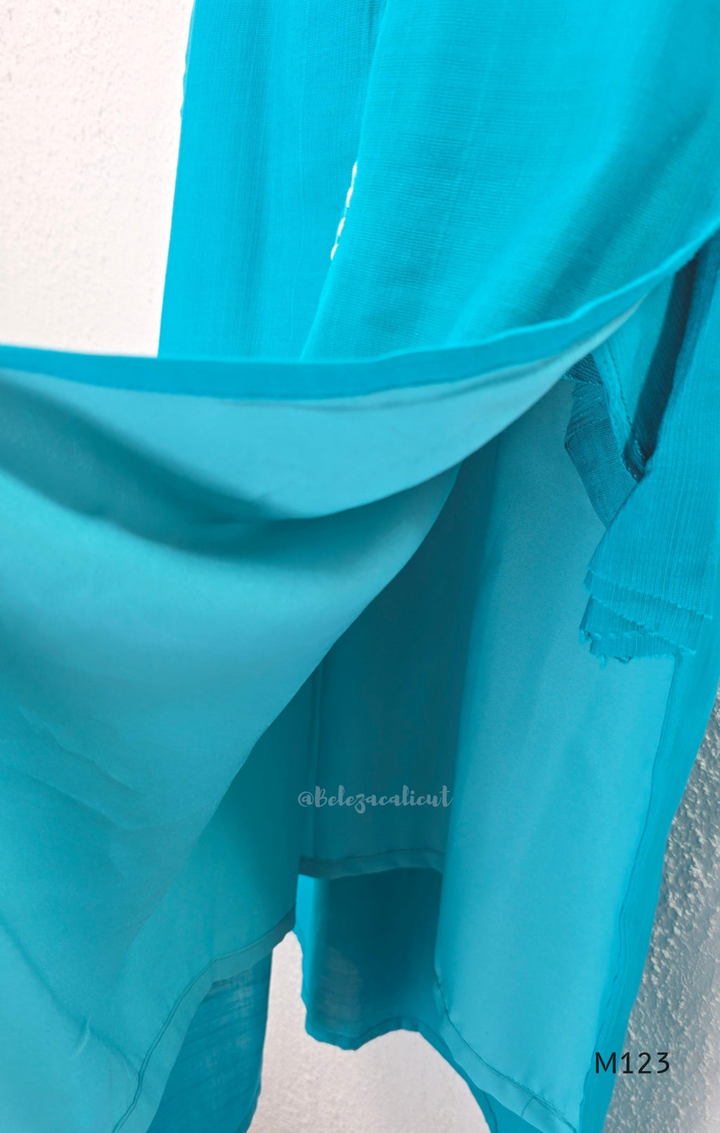 eal blue Vertigan silk coord set with white floral embroidery and straight pants.