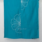 eal blue Vertigan silk coord set with white floral embroidery and straight pants.