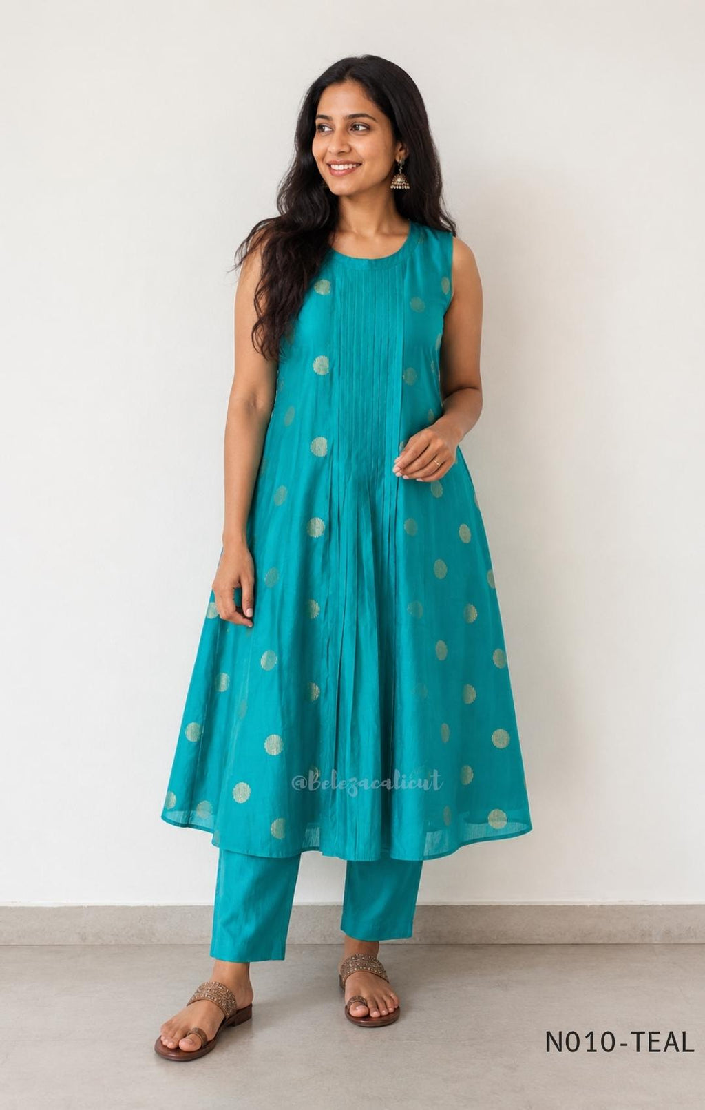 Teal Vertigan silk two-piece coord set with pleated A-line top, gold circular motifs and matching straight pants.