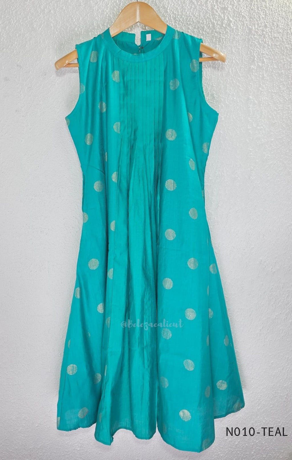 Teal Vertigan silk two-piece coord set with pleated A-line top, gold circular motifs and matching straight pants.