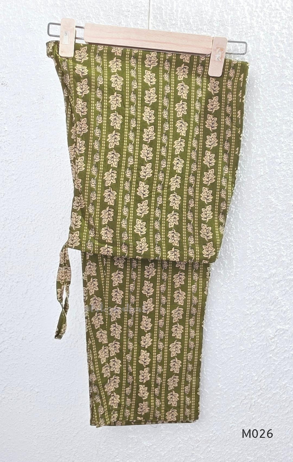 Olive green cotton 3-piece ethnic set with beige leaf print kurta, matching printed pant and dupatta.